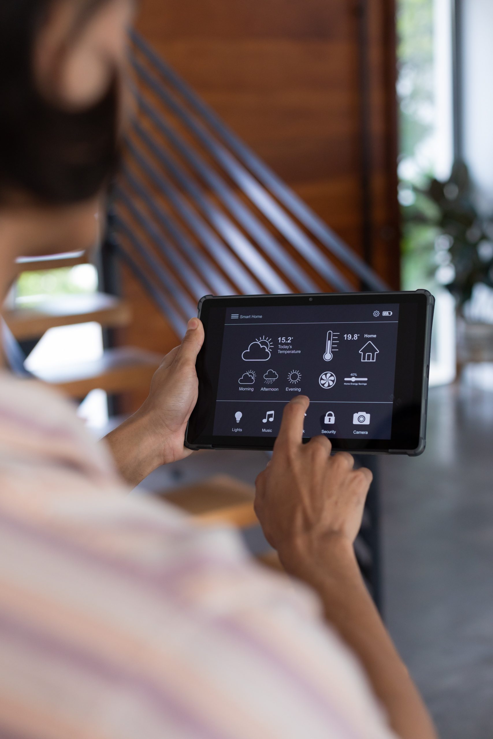 Person using tablet to control Miami smart home features.