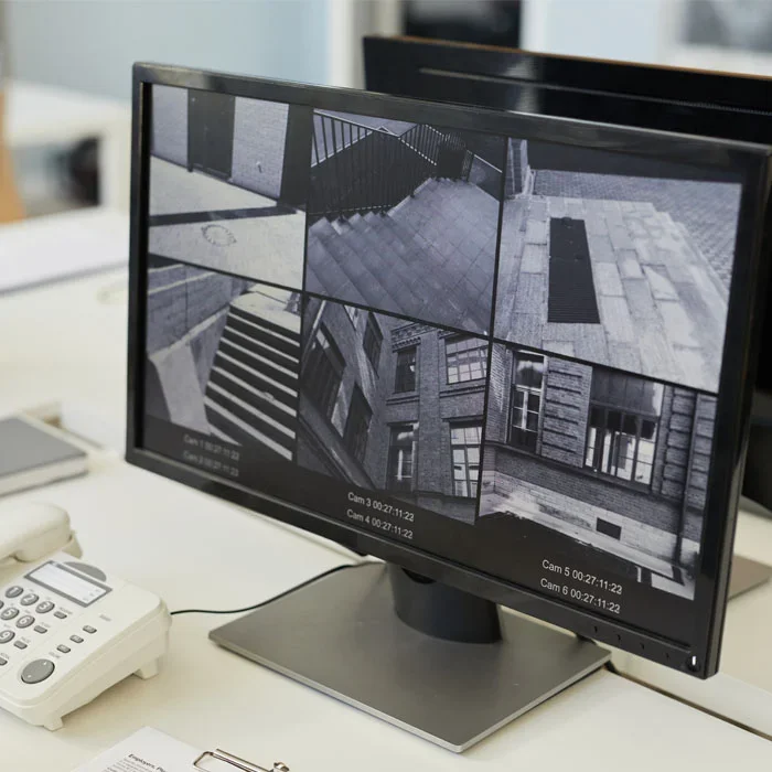 Monitor displaying multi-camera security footage. Secure home surveillance system.